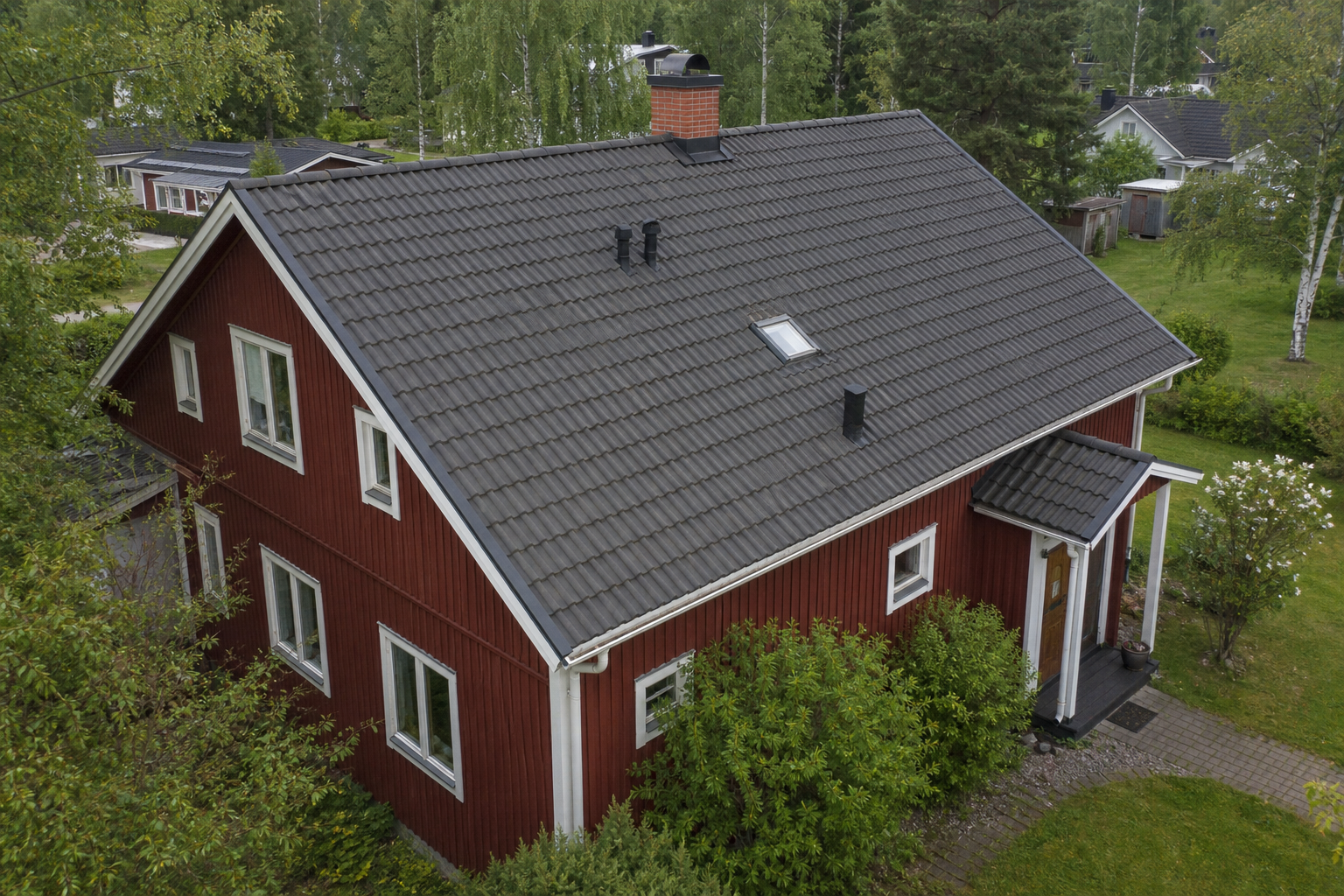 Illustrativ bild av en svensk villa fotograferad från luften, med tak och utvändiga detaljer i bild